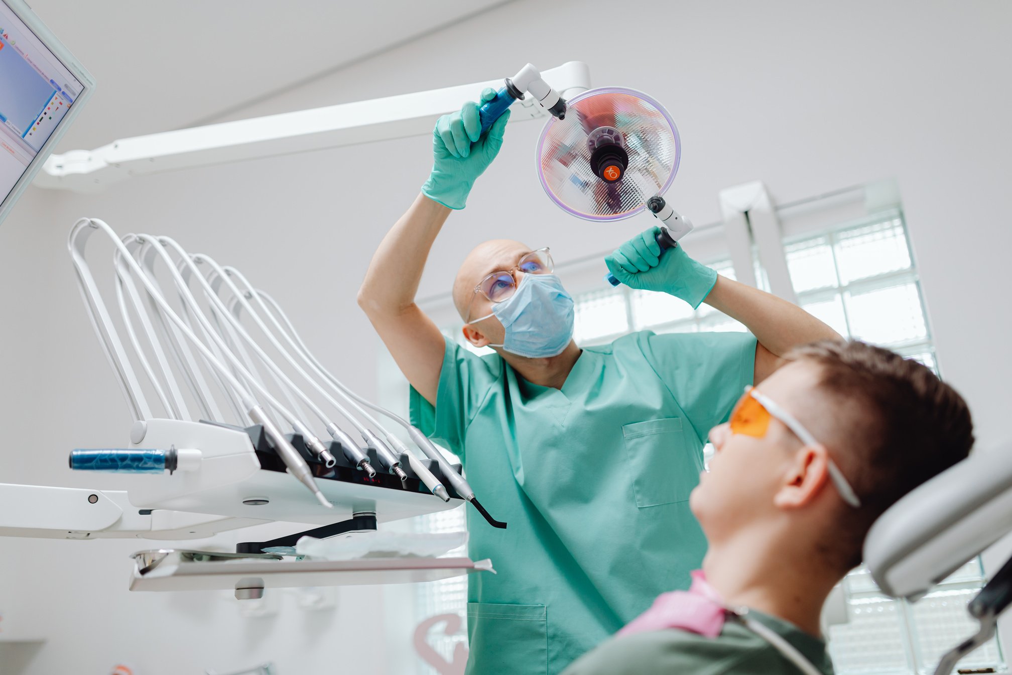 A Dentist Adjusting the Dental Light Stand